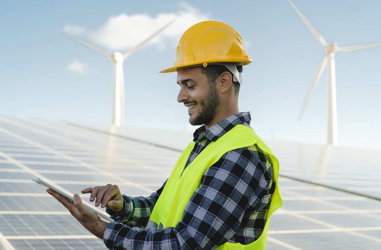 Engineer monitoring renewable energy plan on a tablet